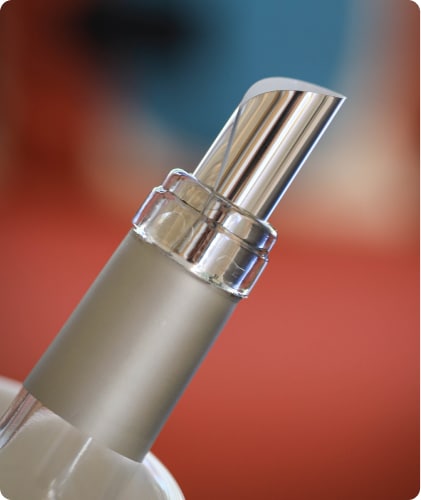 Gros plan sur un DropStop® inséré dans une bouteille de vin, illustrant sa forme cylindrique et son ajustement parfait pour un service sans goutte
